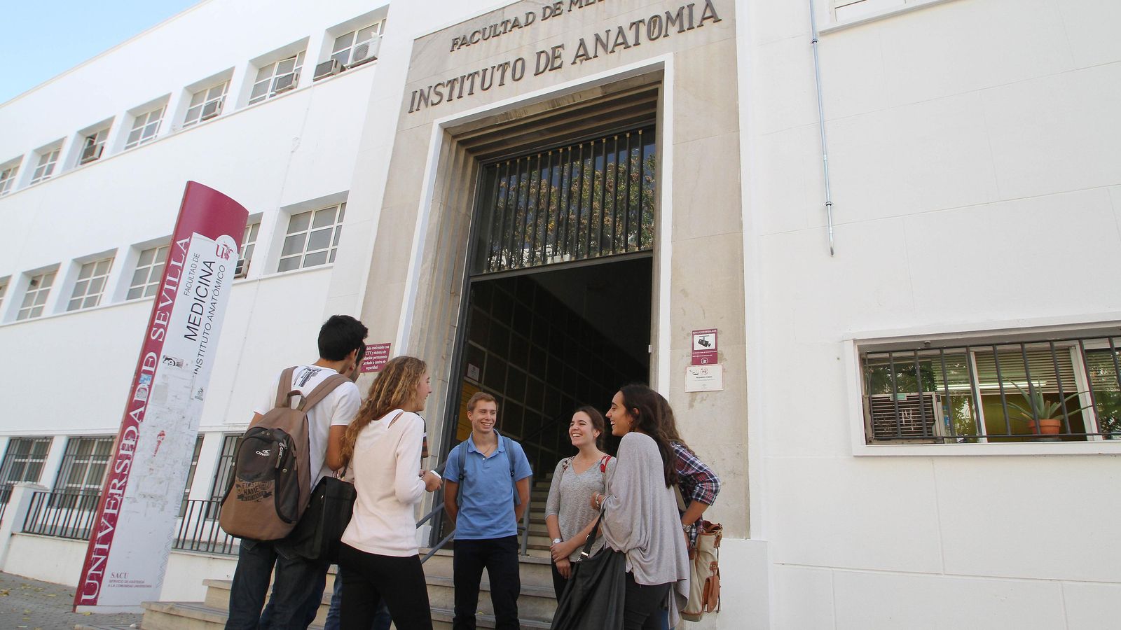 Un grupo de jóvenes en la puerta de la Facultad de Medicina.