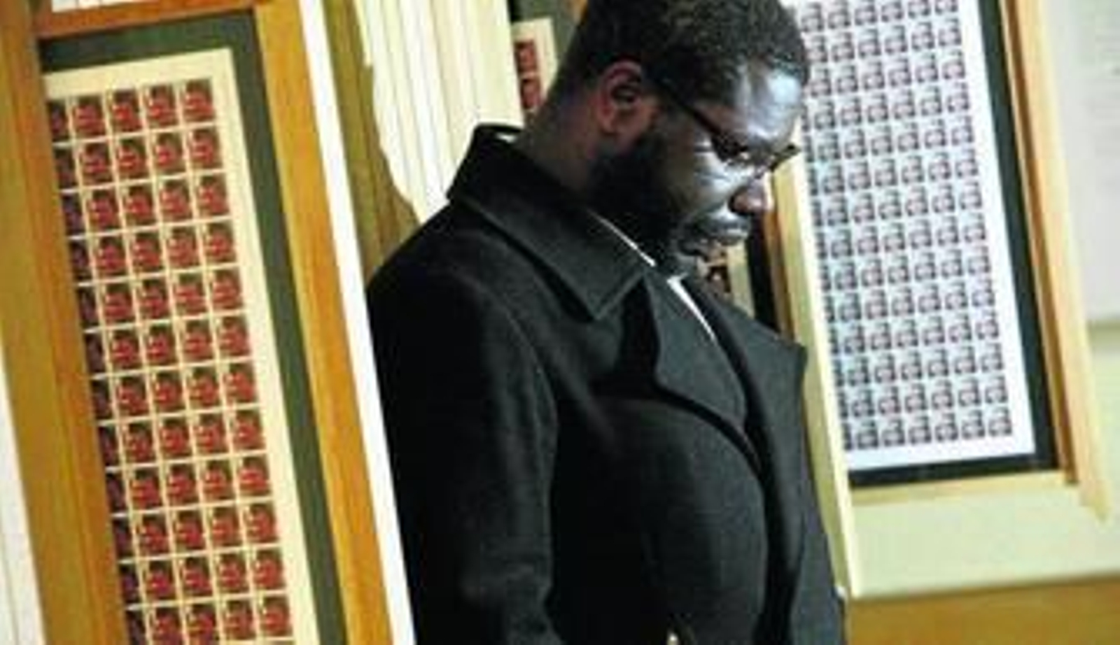 El artista y director de cine Steve McQueen, ante los sellos con soldados muertos en la guerra de Iraq de su exposición 'Queen and Country'.