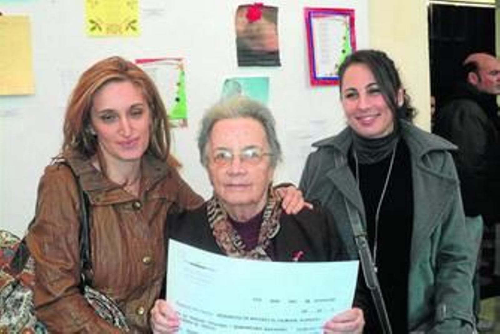 En el centro, la usuaria de la residencia El Palmeral que ha conseguido el premio, junto a dos de sus cuidadoras.
