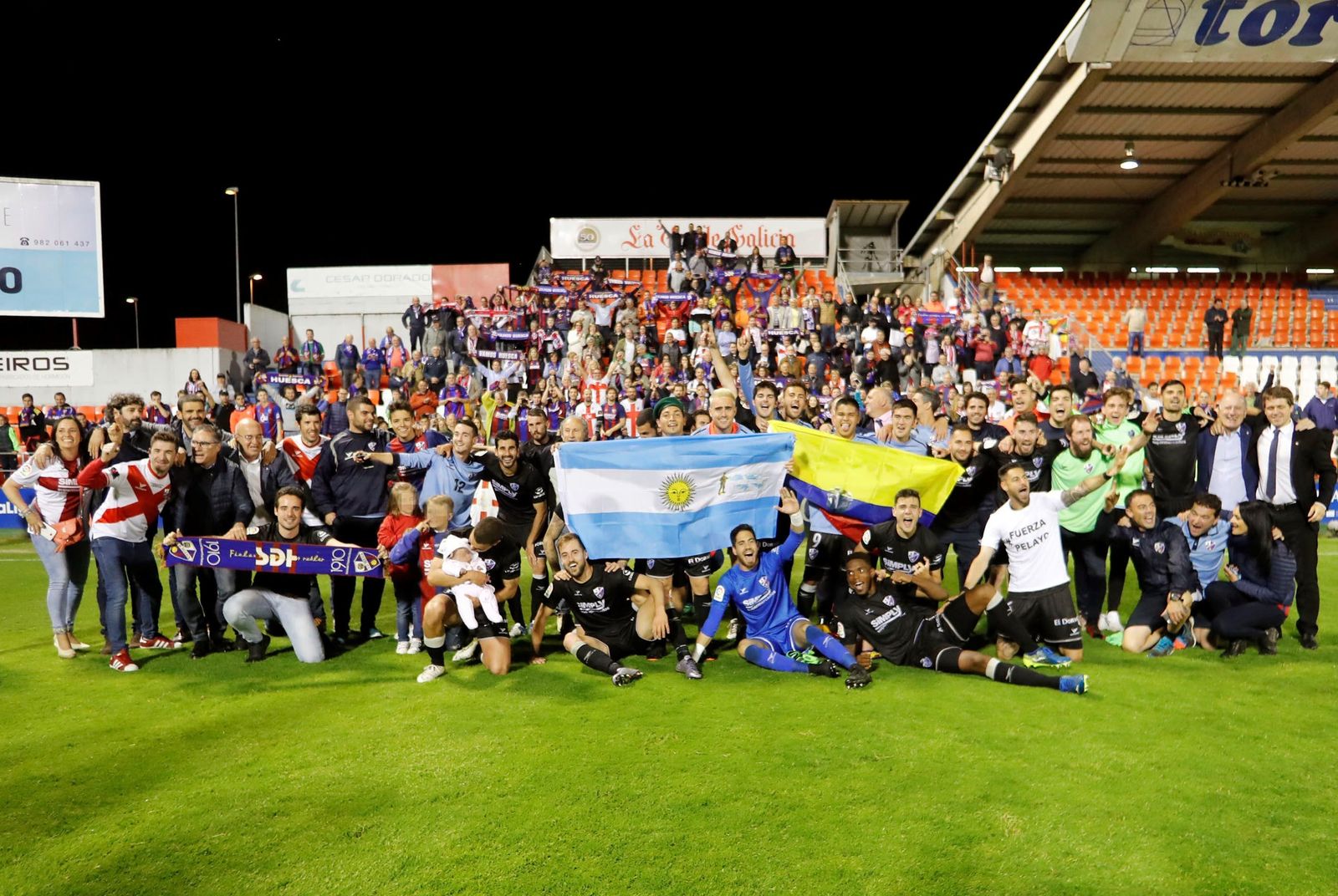 La plantilla del Huesca, con los aficionados desplazados a Lugo de fondo.