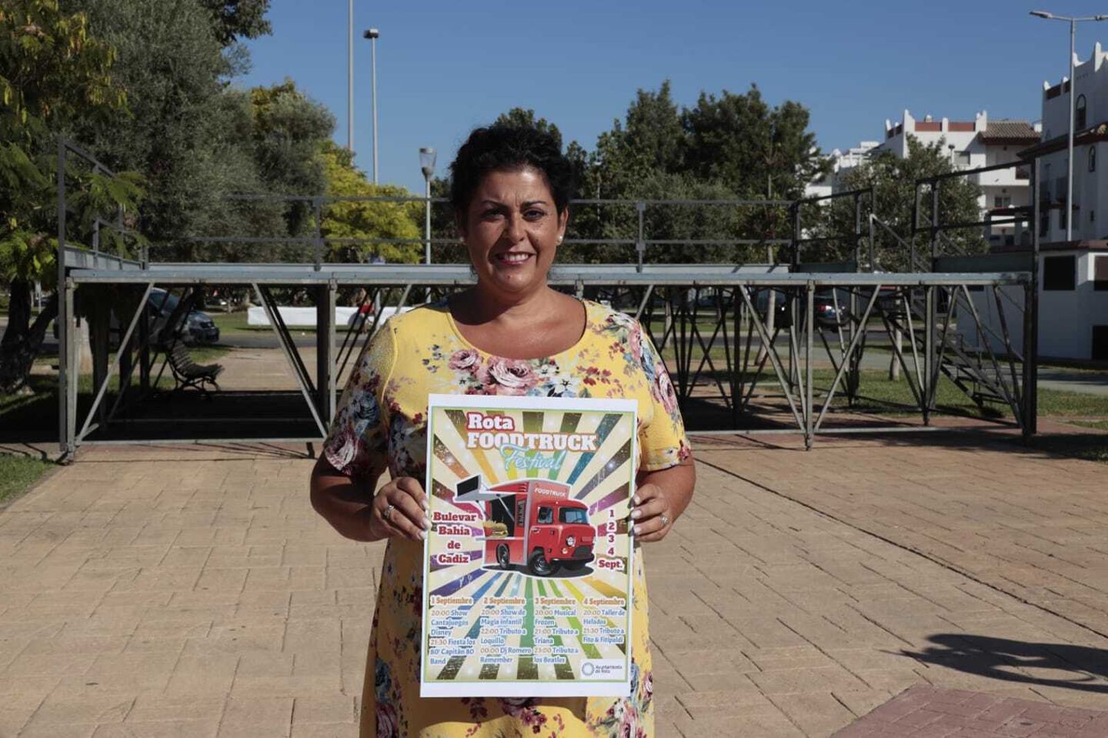 La concejala de Fiestas y Eventos, mostrando el cartel anunciador de este festival en el bulevar Bahía de Cádiz.