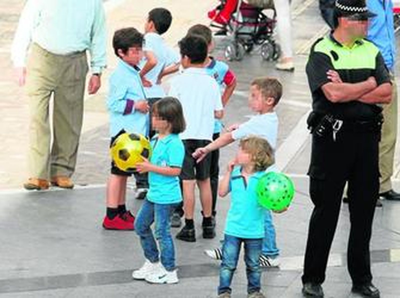 Varios menores juegan a la pelota en la plaza de la Iglesia, junto a un policía local, en una imagen tomada hace unos días.