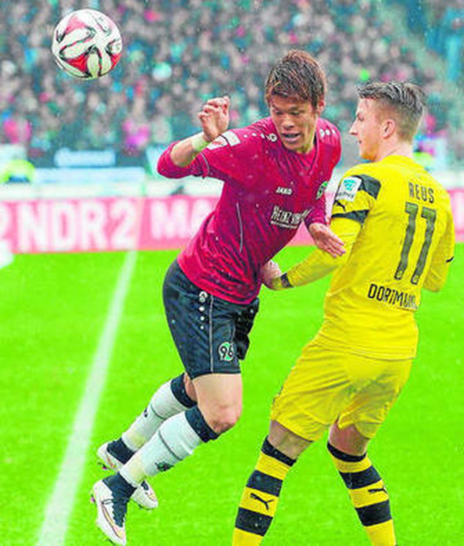 Hiroki Sakai, del Hannover, pelea un balón con Marco Reus.