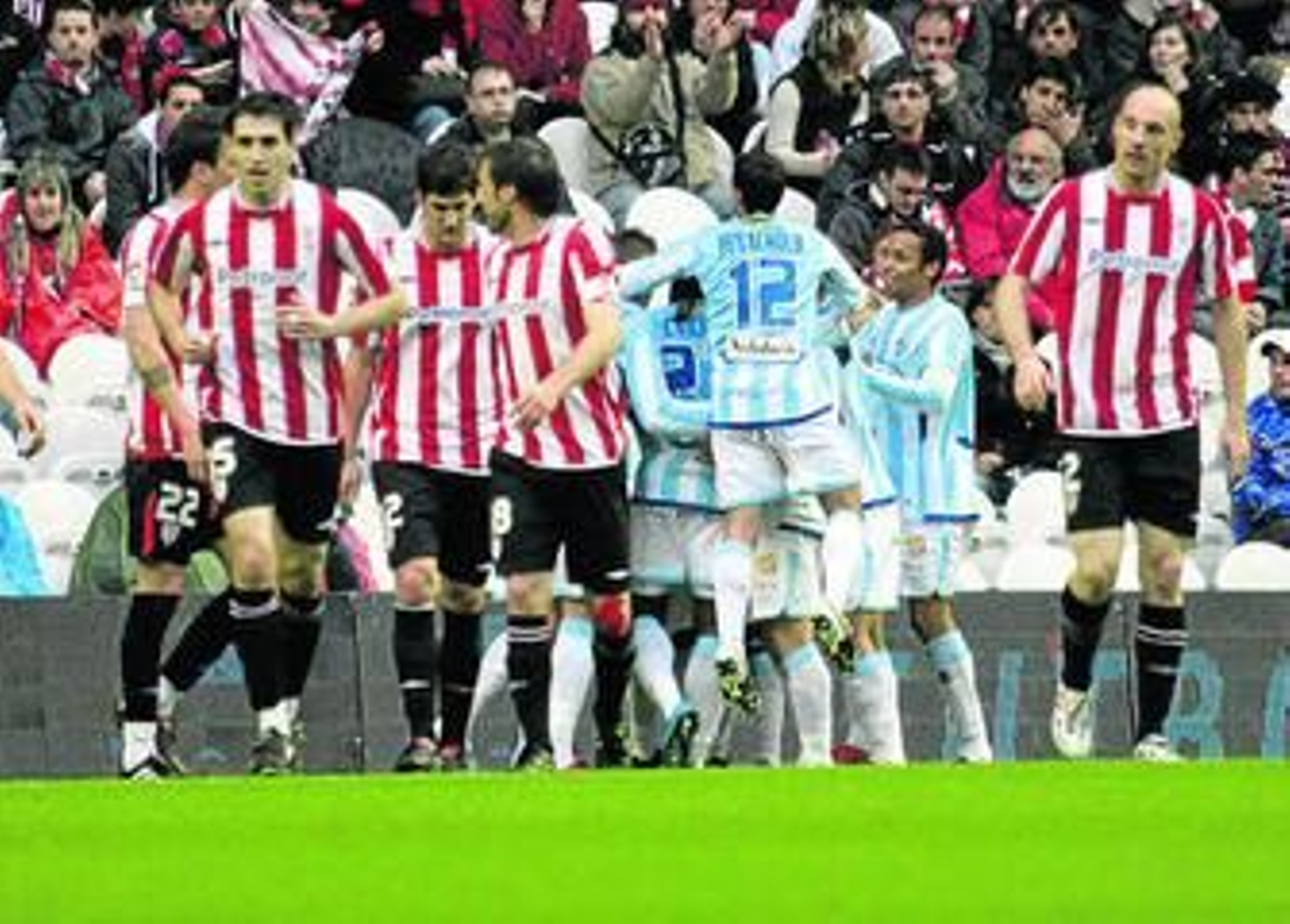 Los jugadores malagueños celebran en una piña el gol de Duda ante la desolación de los bilbaínos. Los jugadores malagueños celebran en una piña el gol de Duda ante la desolación de los bilbaínos.
