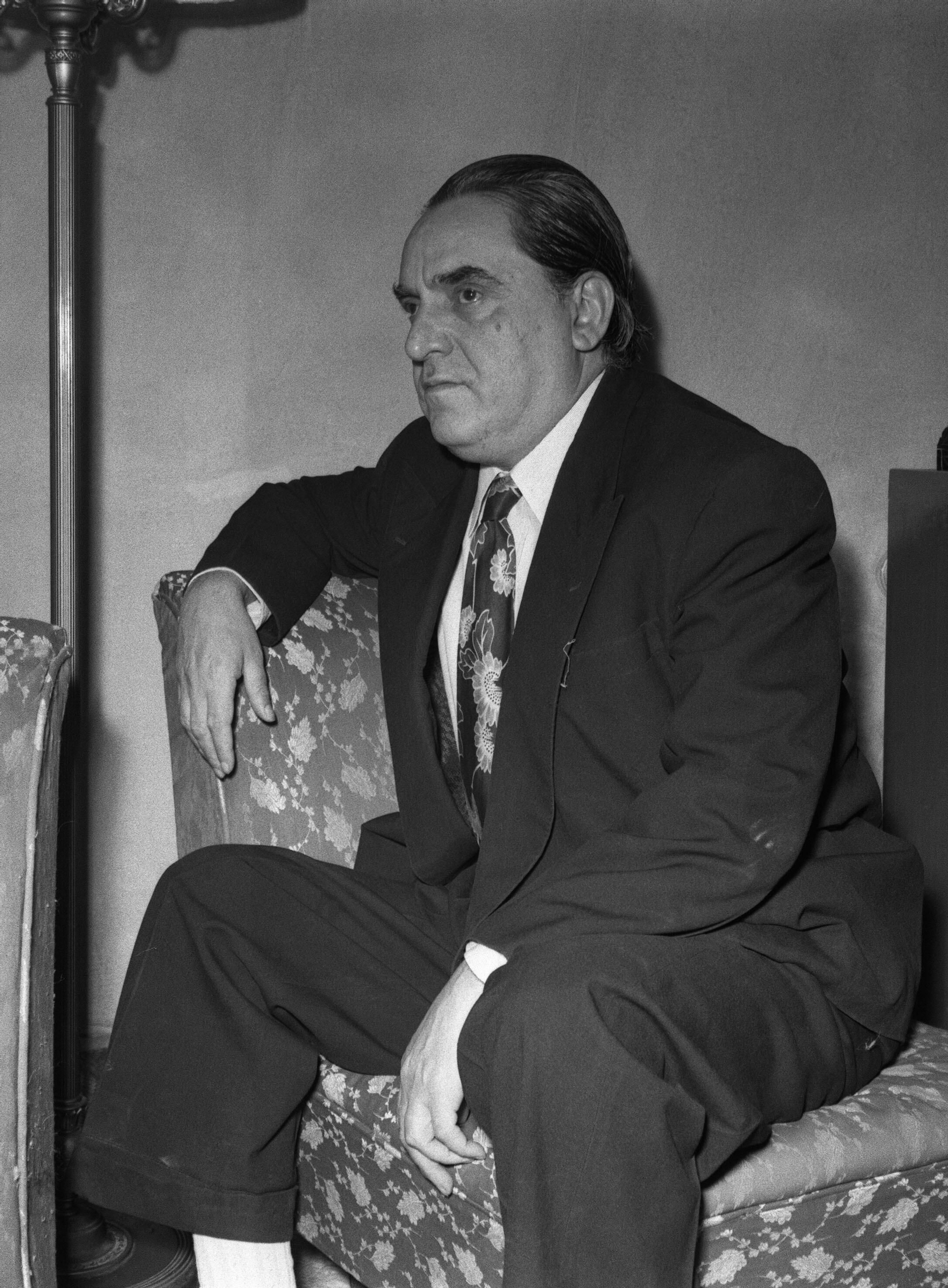 Garfias en el retrato de cuerpo entero, trajeado y con colorista corbata.