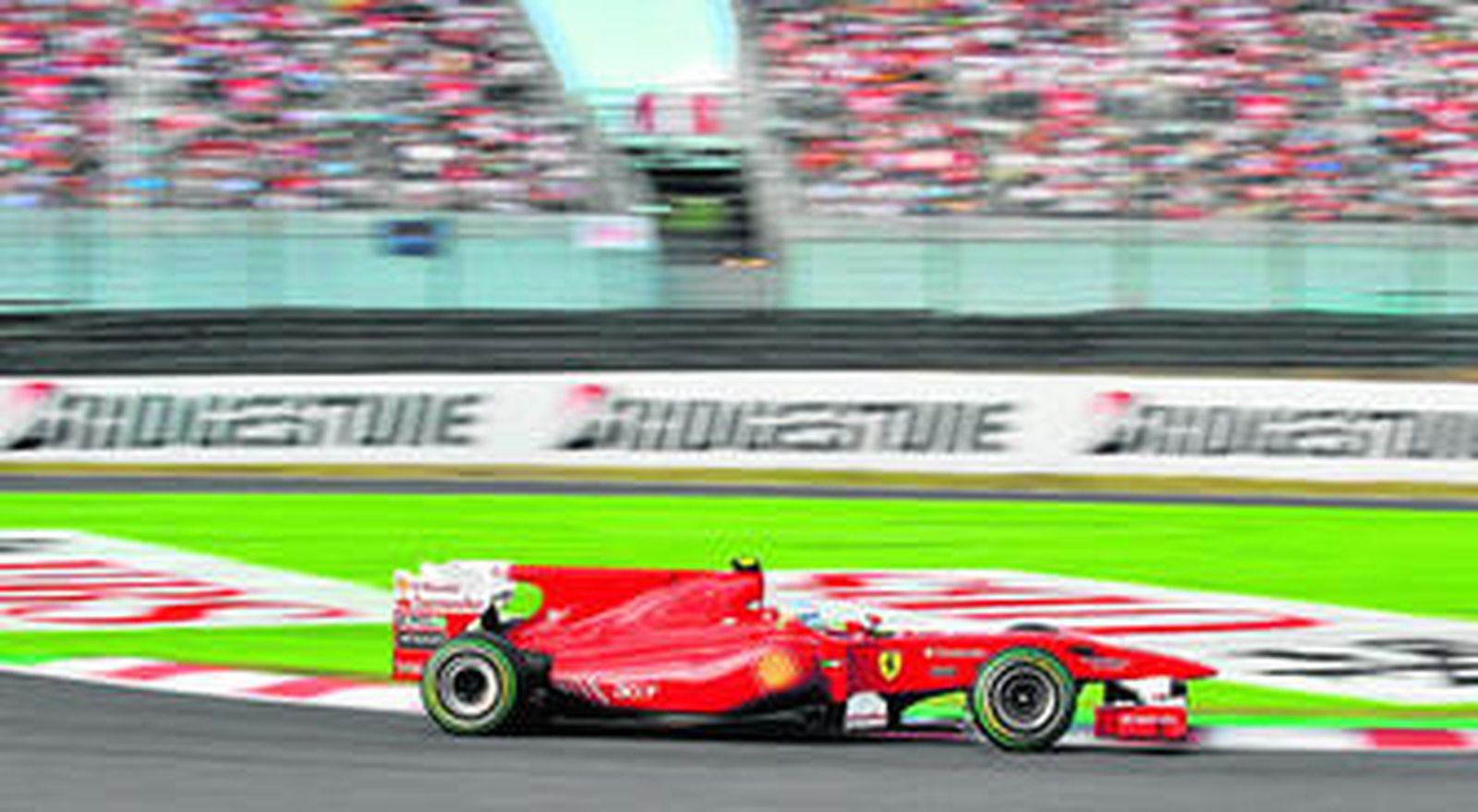 El Ferrari de Fernando Alonso pasa delante de una de las abarrotadas gradas del circuito de Suzuka durante el Gran Premio disputado en Japón.
