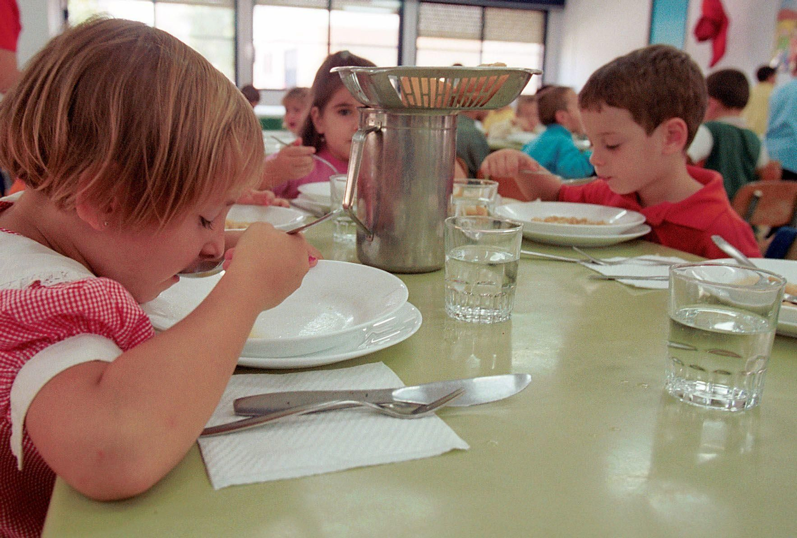 Fotografía que muestra a varios escolares comiendo en el comedor de la escuela