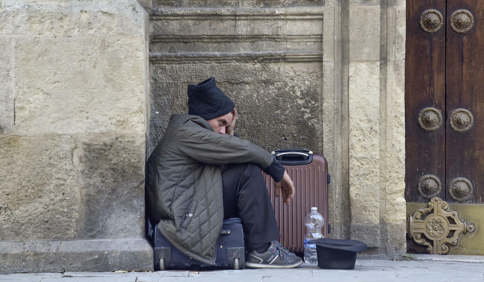 Un indigente pide limosnas a las puertas de una iglesia en Sevilla.