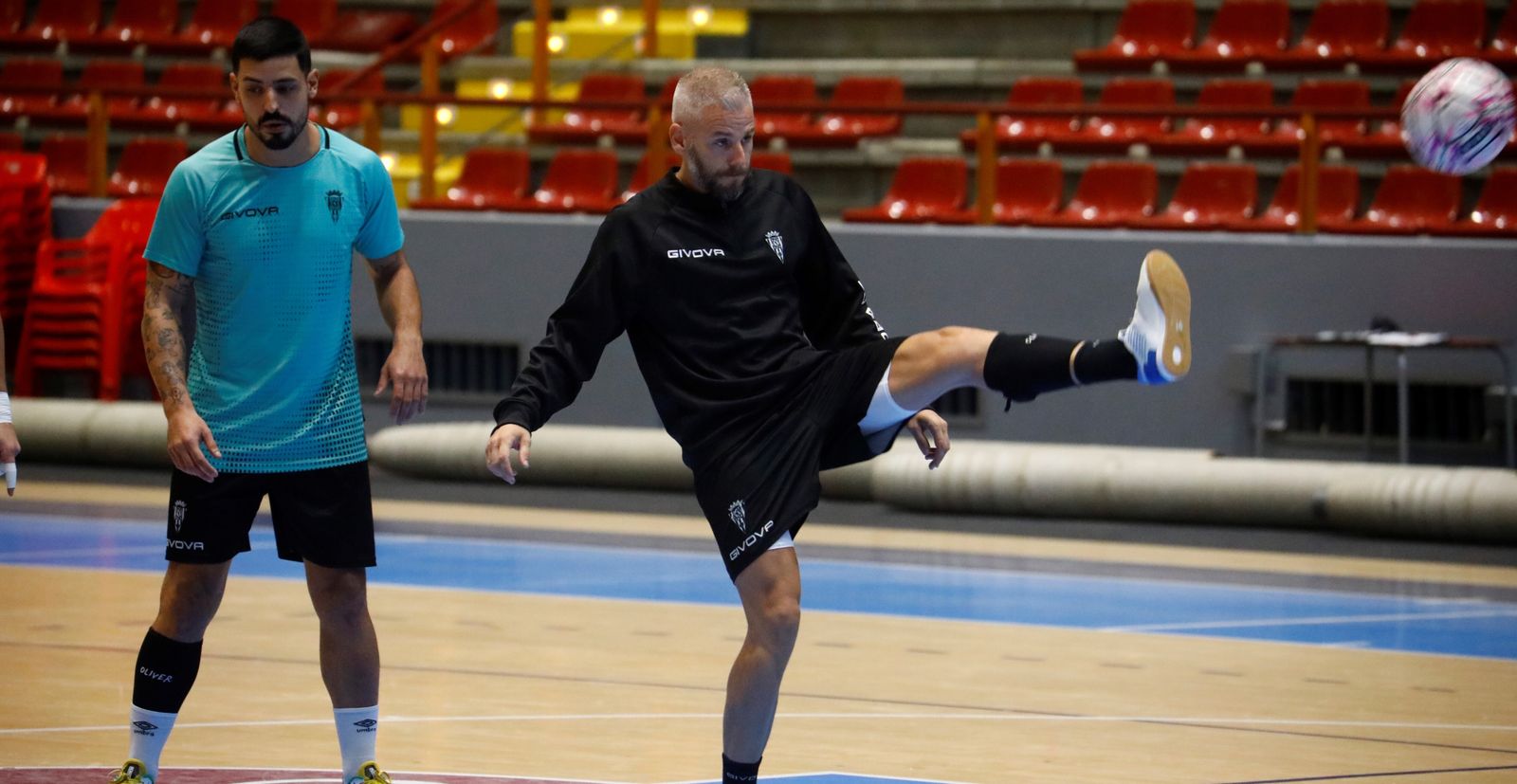 Miguelín golpea el balón en un entrenamiento del Córdoba Futsal, con Jesús Rodríguez tras él.