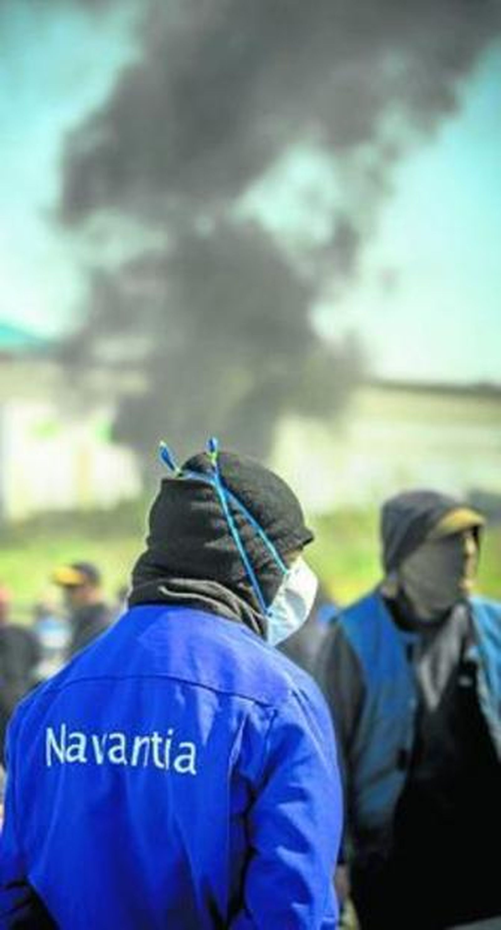 Un empleado de Navantia Puerto Real, con humo al fondo durante una protesta.