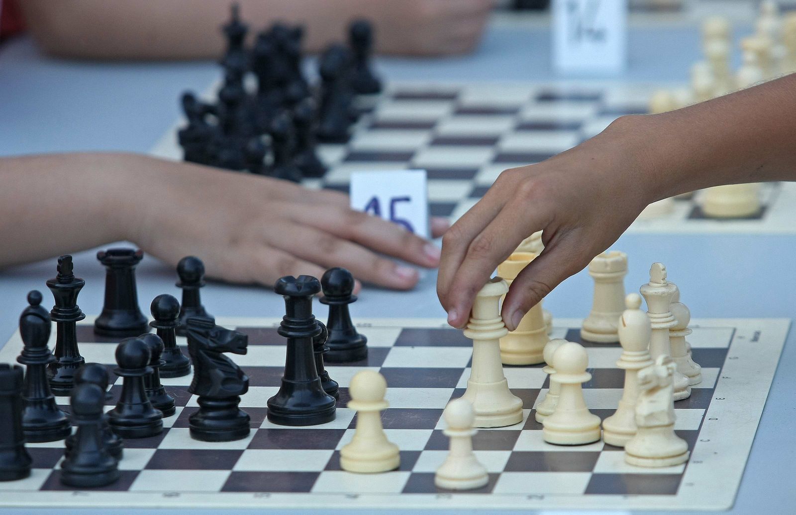 Dos niños juegan al ajedrez.