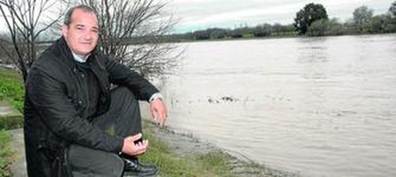 Rafael Baena, en la orilla del Guadalquivir, muy caudaloso y arrastrando mucho sedimento que le da color de chocolate, junto al paseo de San Juan de Aznalfarache y la fábrica de Herba.