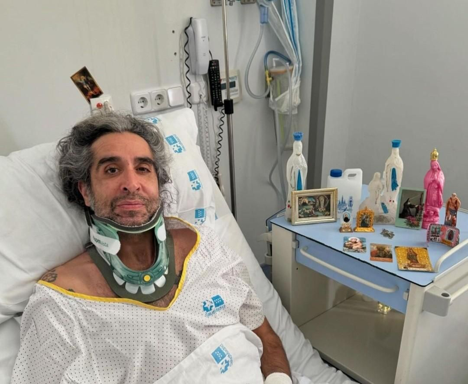 Mario Vaquerizo en la cama del hospital y los santos y representaciones marianas que tiene a su lado