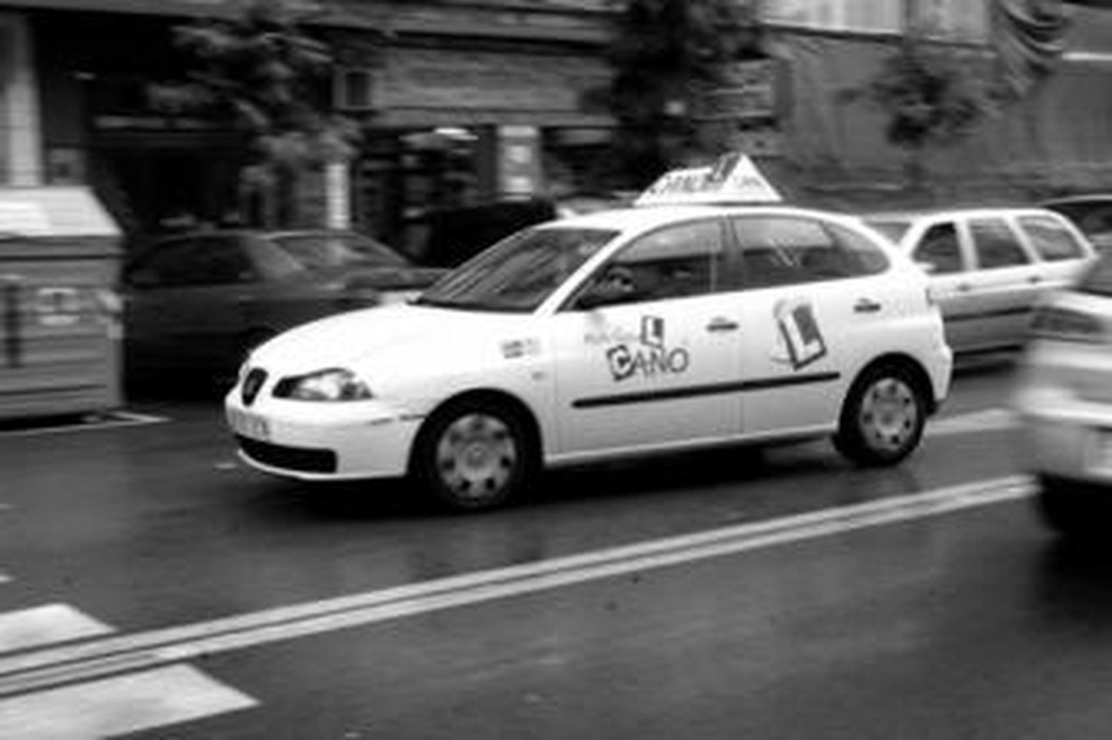 Un coche de autoescuela circula por la avenida Fuerzas Armadas de Algeciras.