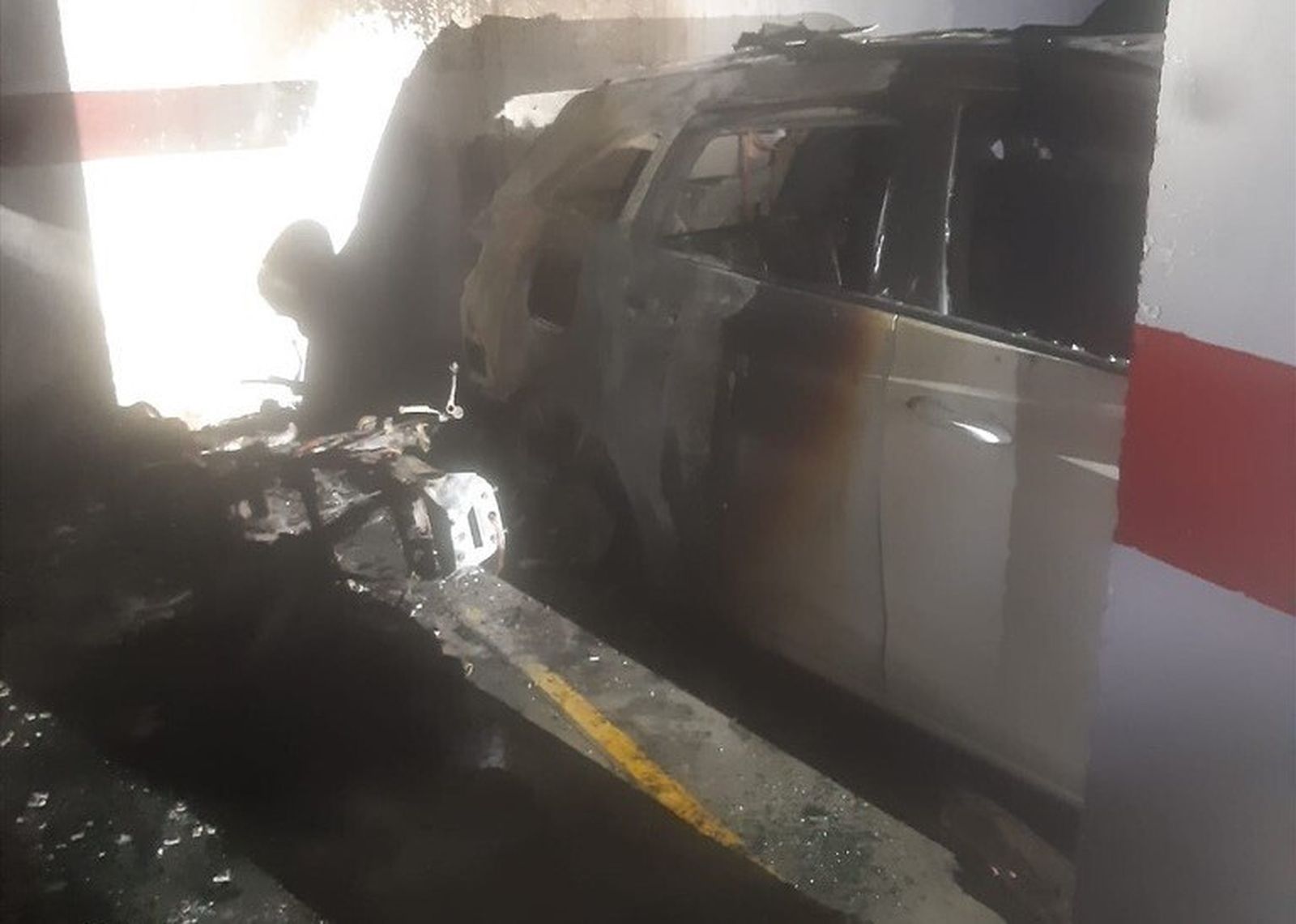 Una moto y uno de los coches calcinados por el incendio en el garaje