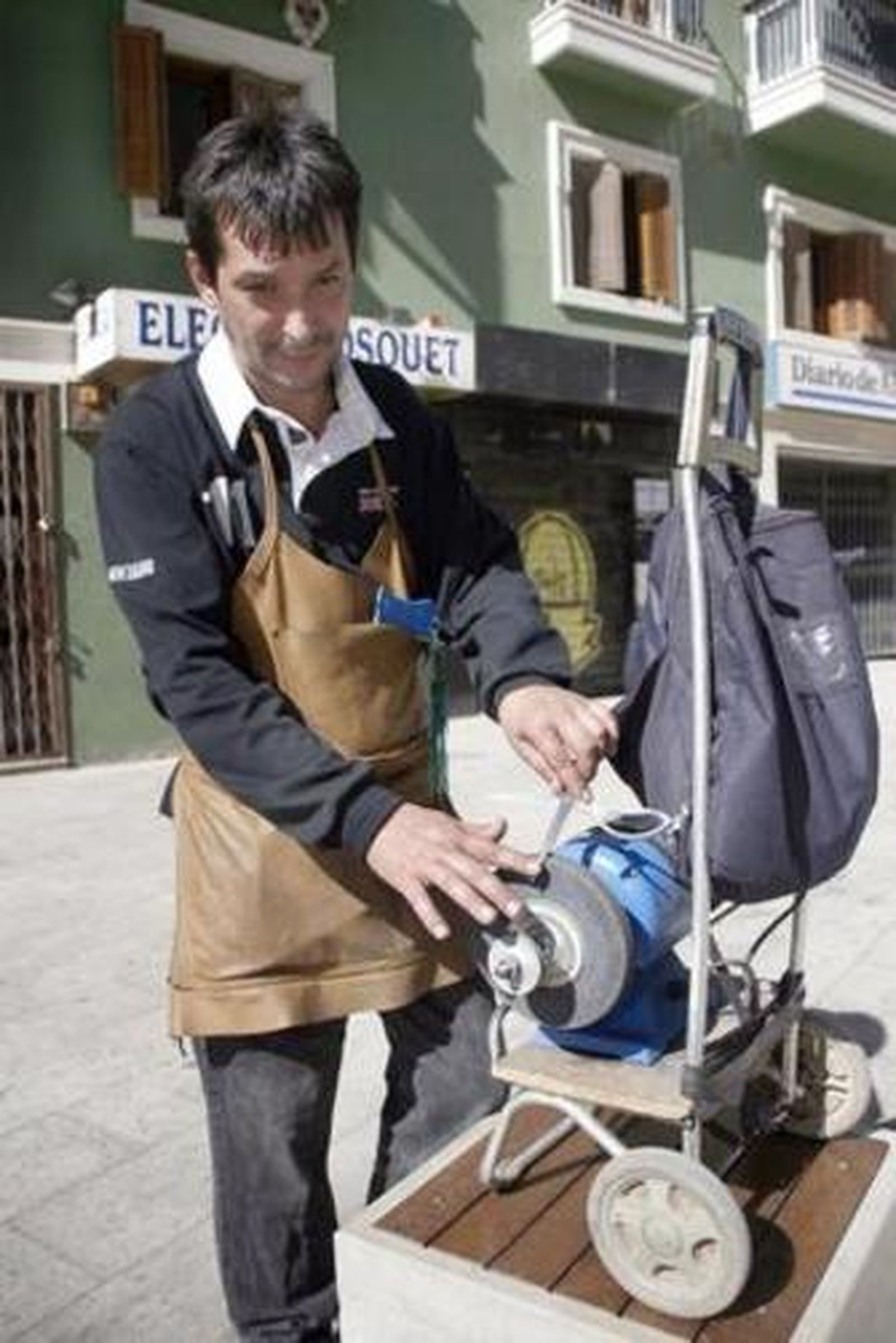 Jonathan Martínez afila unas tijeras en la máquina (Rafael González)