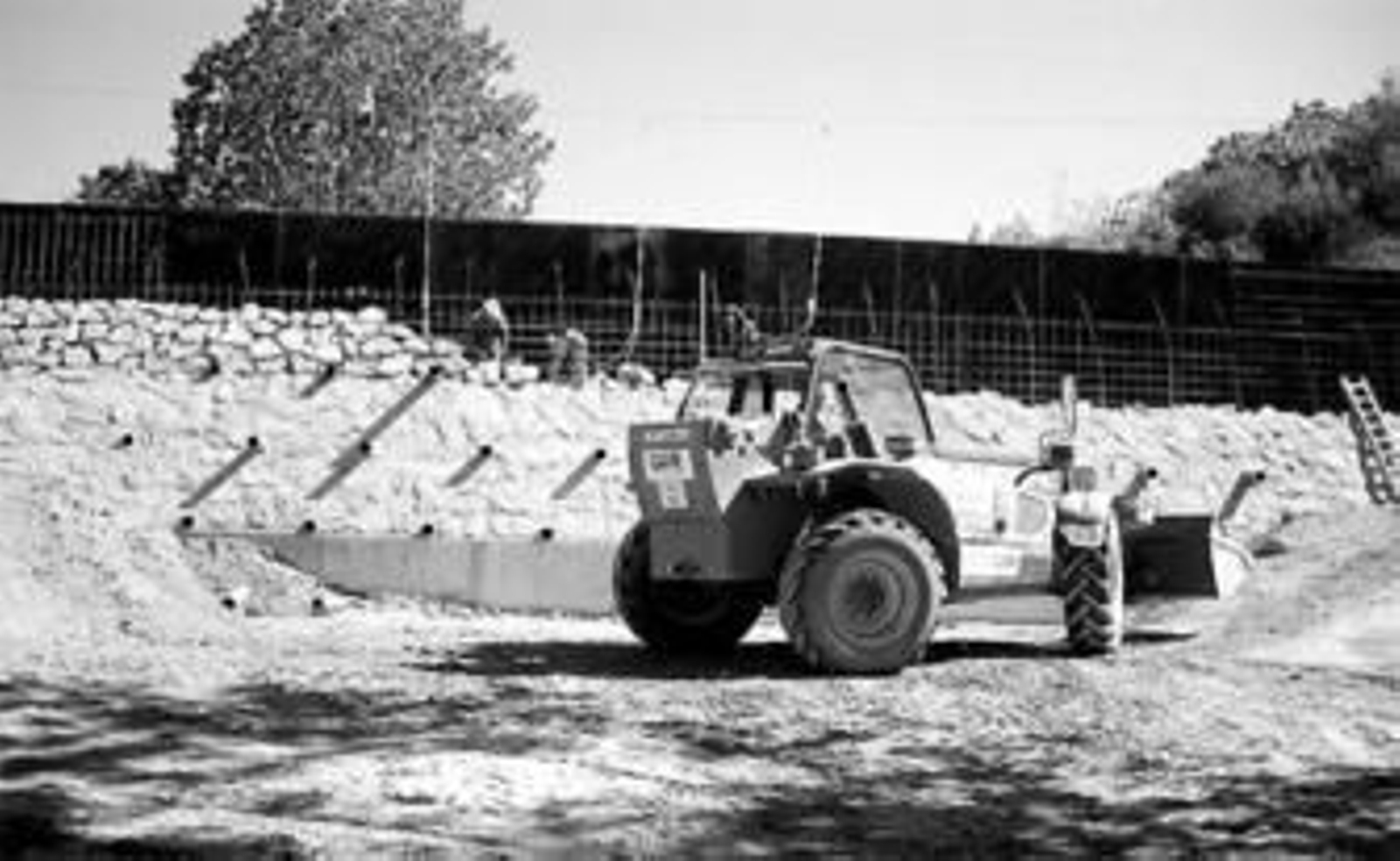 Varios obreros trabajan en la construcción de un dique en un arroyo de Rincón de la Victoria.