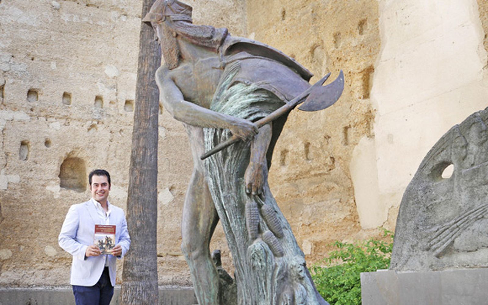 Jesús Ángel Rojo posa ayer con su libro junto al olvidado monumento a Álvar Núñez en la calle Ancha.  /Vanesa Lobo
