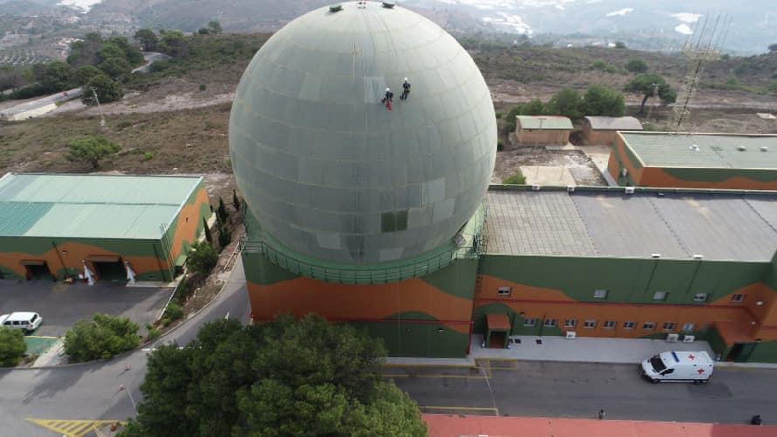 Vista aérea del EVA- 9 con dos trabajadores sobre el radomo Vista aérea del EVA- 9 con dos trabajadores sobre el radomo
