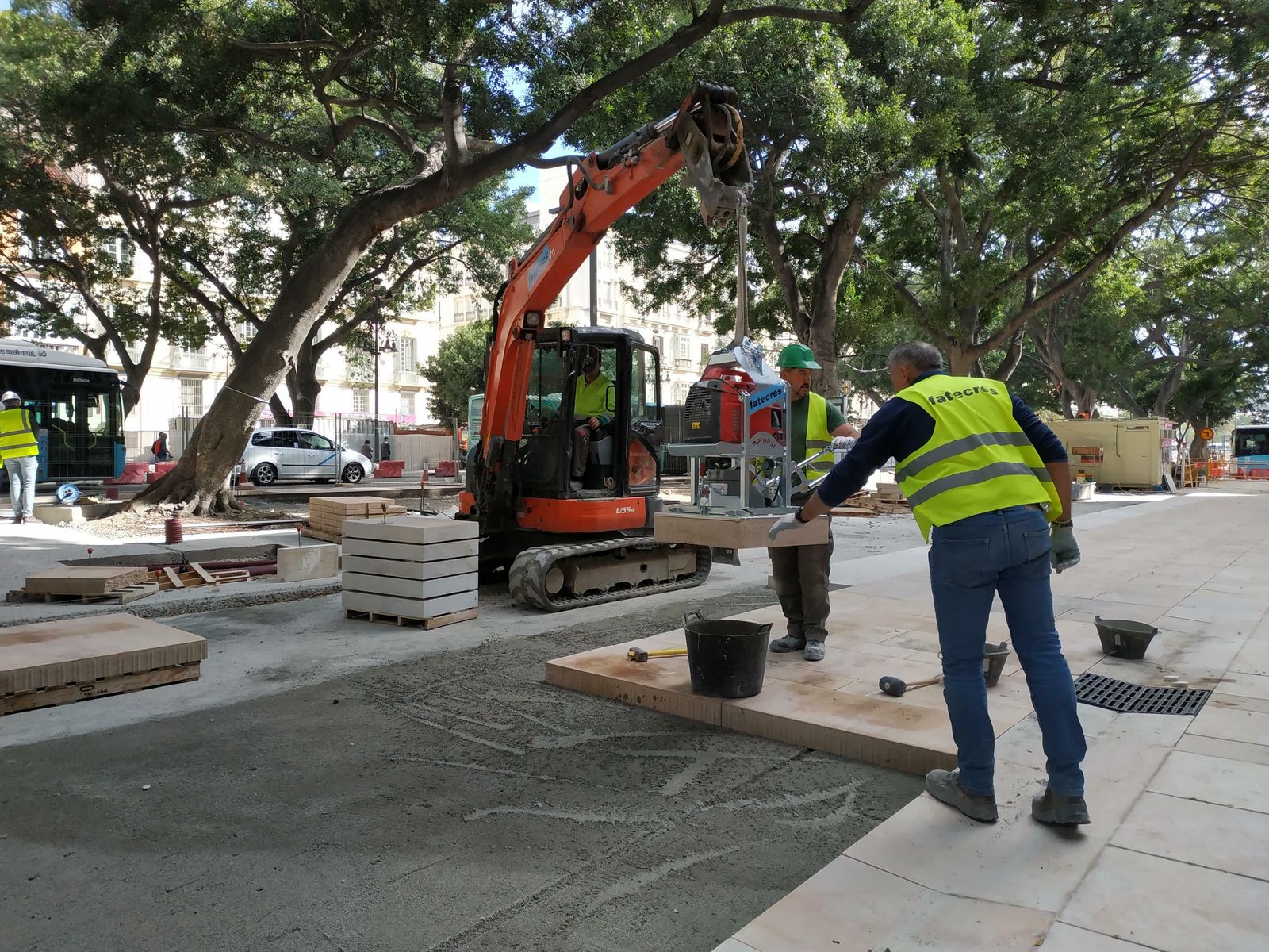 Obreros colocan una pieza del nuevo pavimento en el lateral sur de la Alameda.