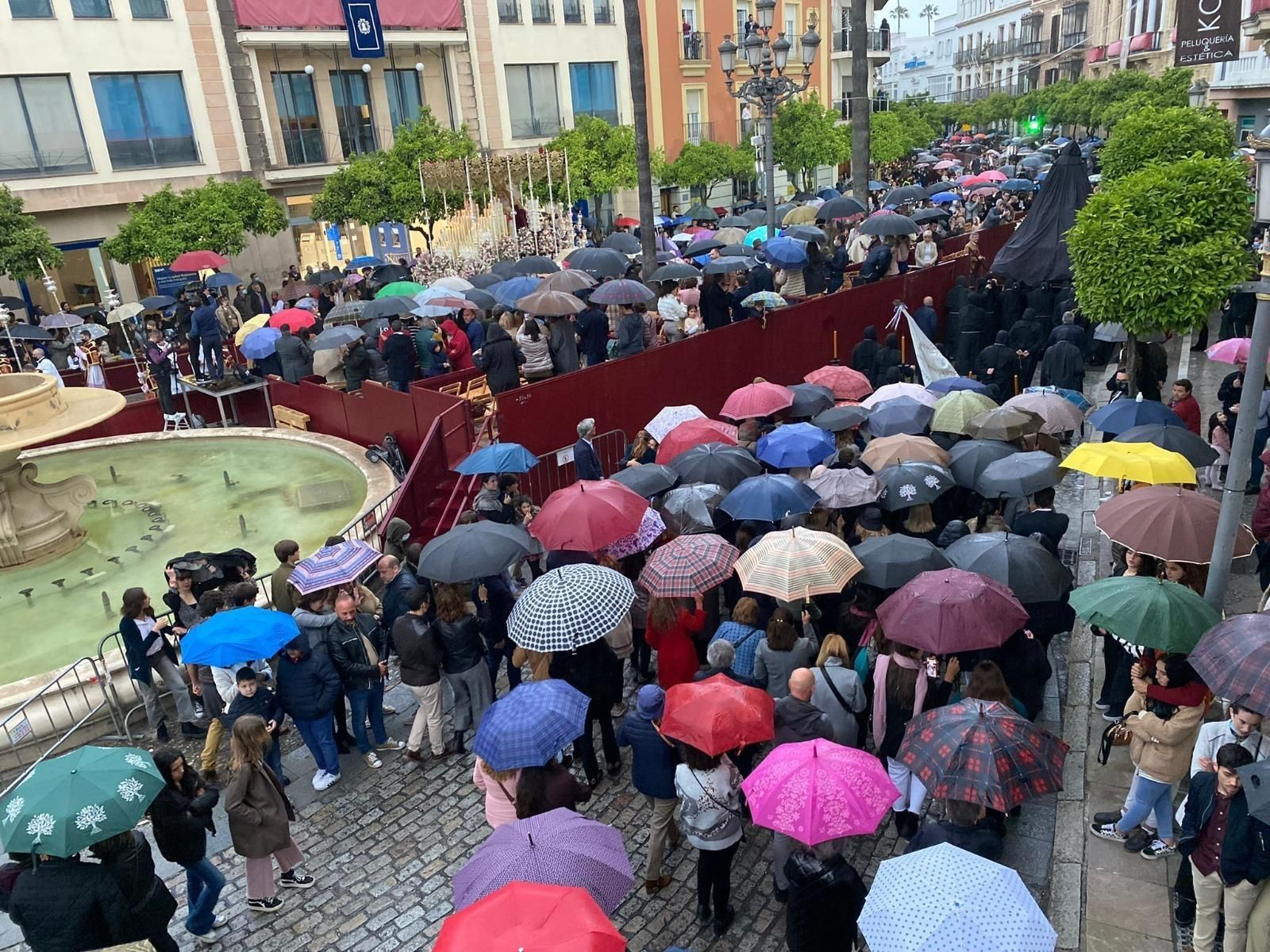 El palio de la Candelaria pasando por la calle Larga con el público con paraguas.