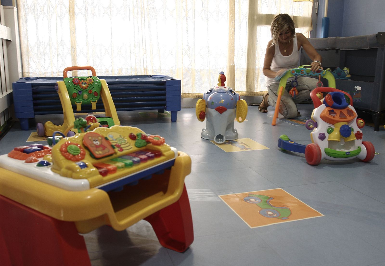 La trabajadora de una guardería prepara los juguetes.