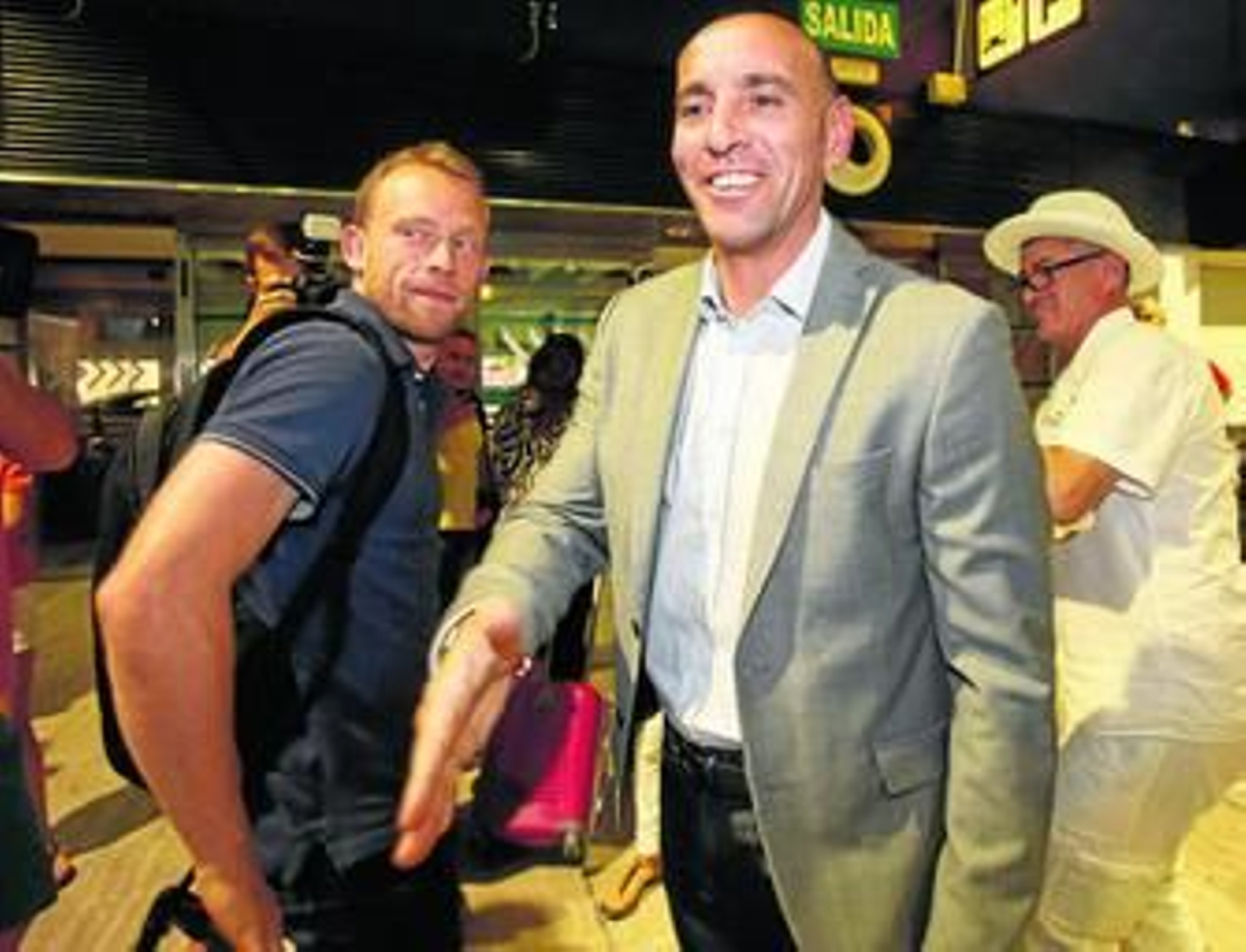 Monchi saluda a un aficionado ante Krohn-Dehli, recién llegado a Sevilla.