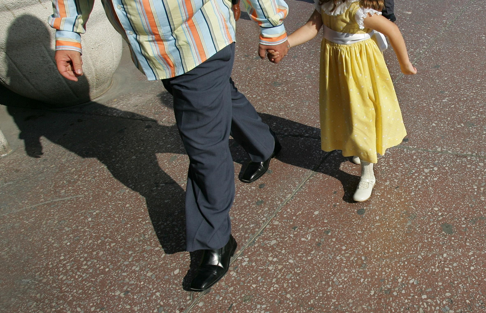 Un padre y una hija paseando por las calles de Málaga