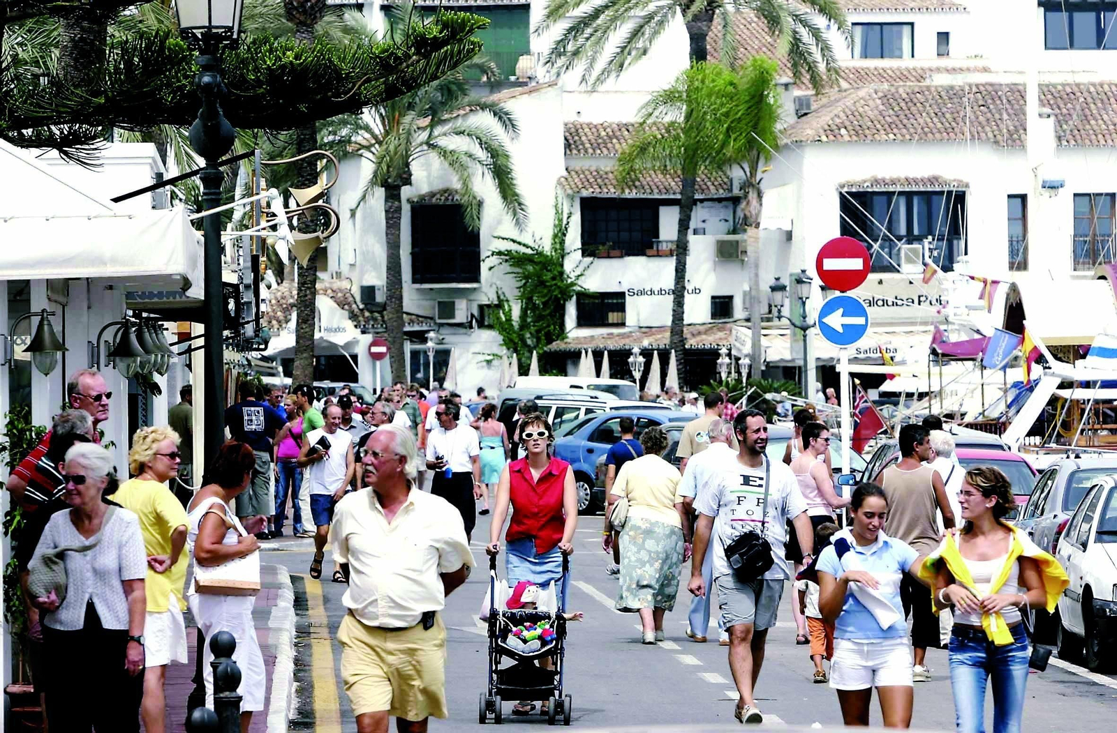 Centenares de personas pasean por Puerto Banús en Marbella.