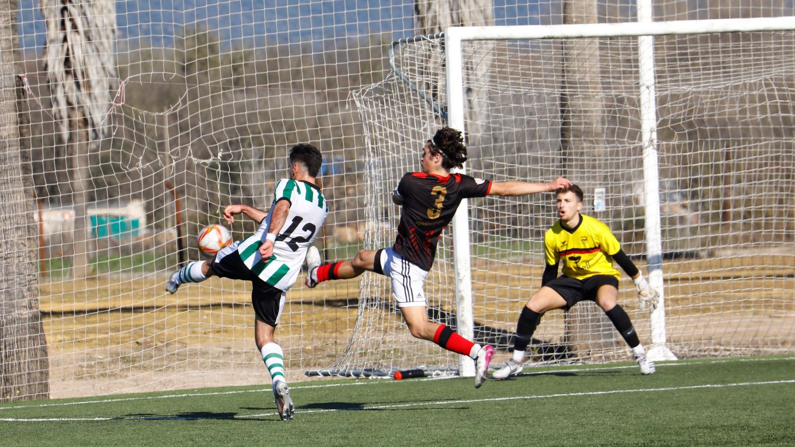 Adri dispara a portería con Rafa Álvarez intentando repeler el balón.