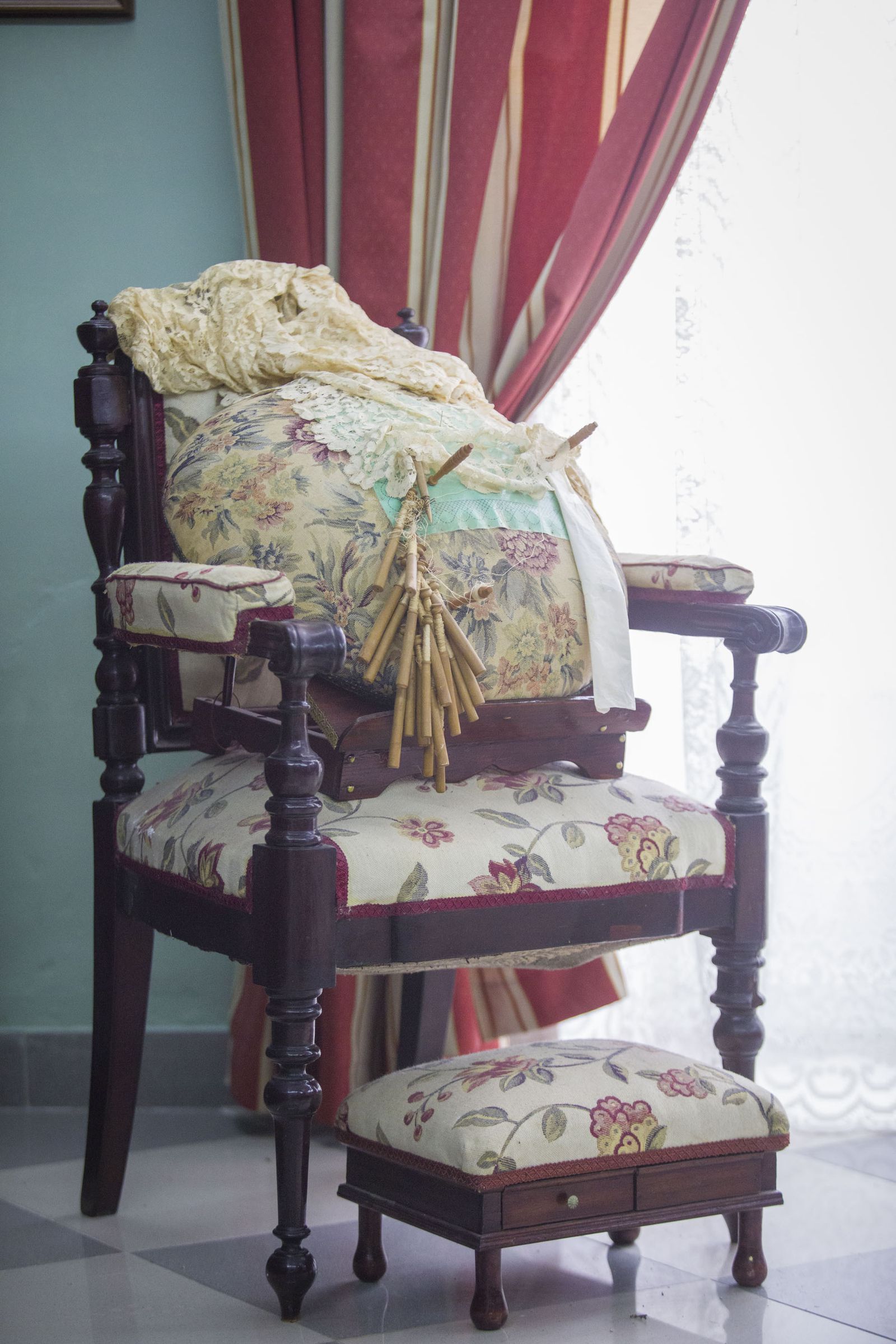 Antiguo silllón para hacer encajes de bolillos, con el mundillo y sus bolillos.