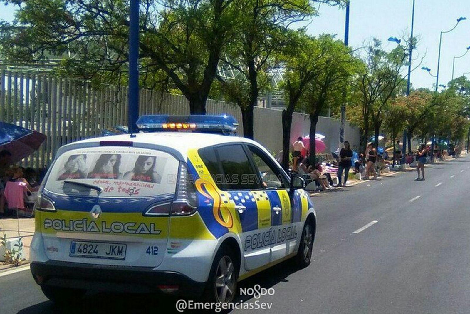 Un coche de la Policía Local, en un tramo de la cola.