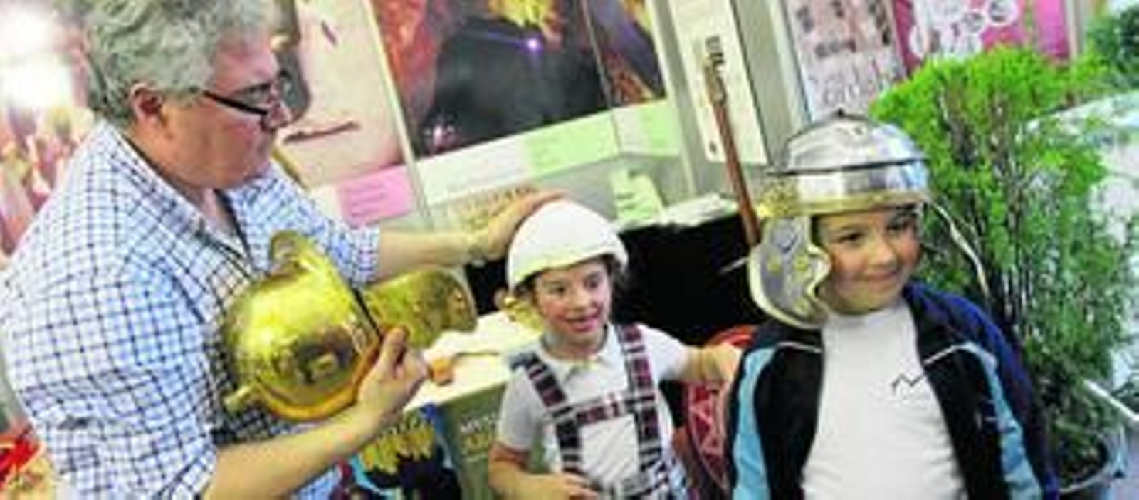 Unos niños se ponen unos cascos de la época de pujanza de Torreparedones.