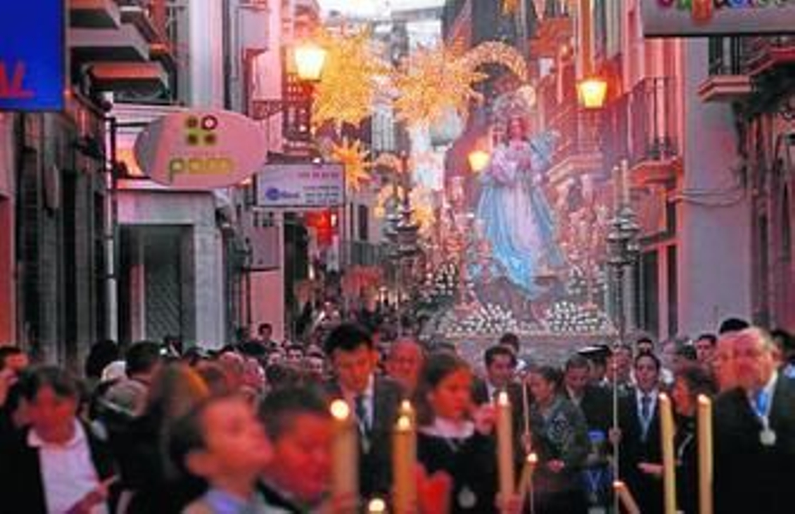 A la izquierda, la Inmaculada por la calle Berdigón, iluminada con las luces de Navidad. A la derecha, músicos de la Banda de la Salud. Sobre estas líneas, una niña reparte estampas. A la izquierda, la Inmaculada por la calle Berdigón, iluminada con las luces de Navidad. A la derecha, músicos de la Banda de la Salud. Sobre estas líneas, una niña reparte estampas.