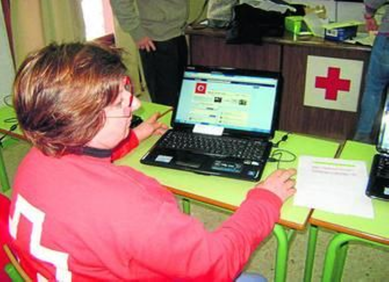 Una voluntaria de Cruz Roja ante un ordenador en la sede de Huelva.