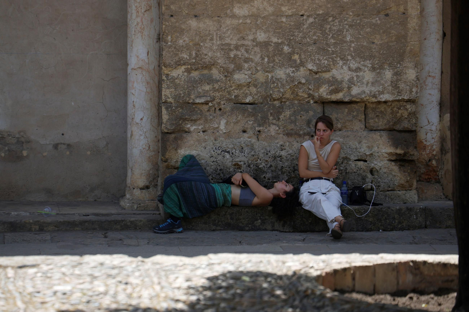 Dos jóvenes descansan a la sombra.