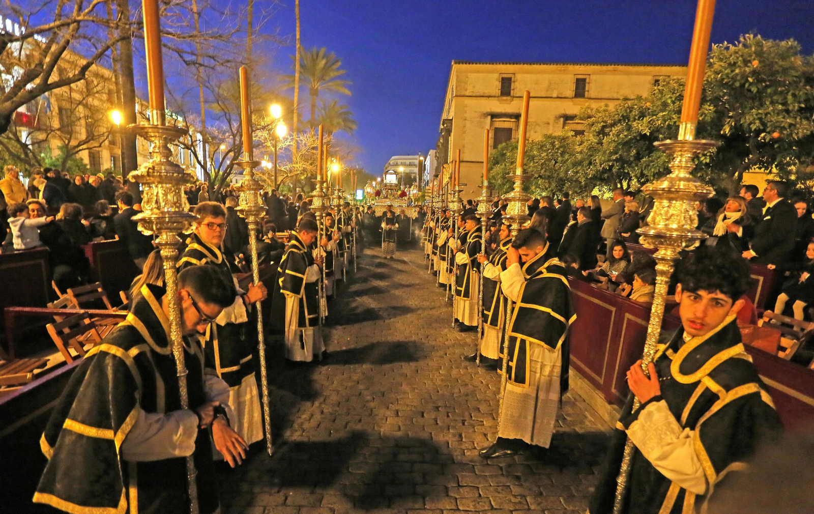 Los dieciocho ciriales que preceden a la urna son un signo litúrgico único en el Santo Entiero que, de esta forma, pone en evidencia la solemnidad de esta procesión.