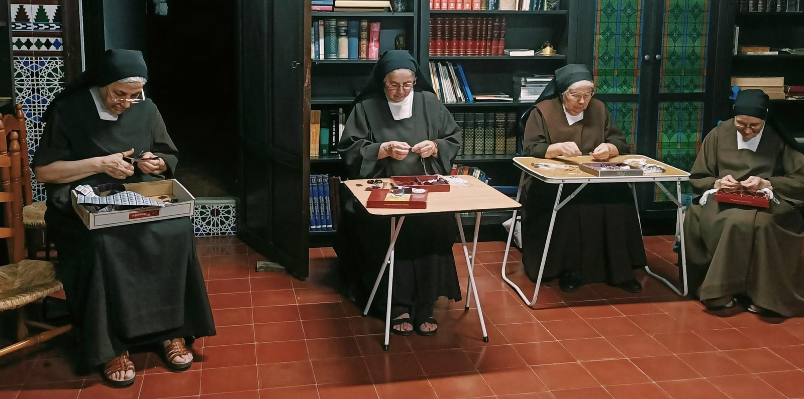 Varias religiosas de Las Teresas confeccionan los escapularios carmelitas en la hora de la recreación.
