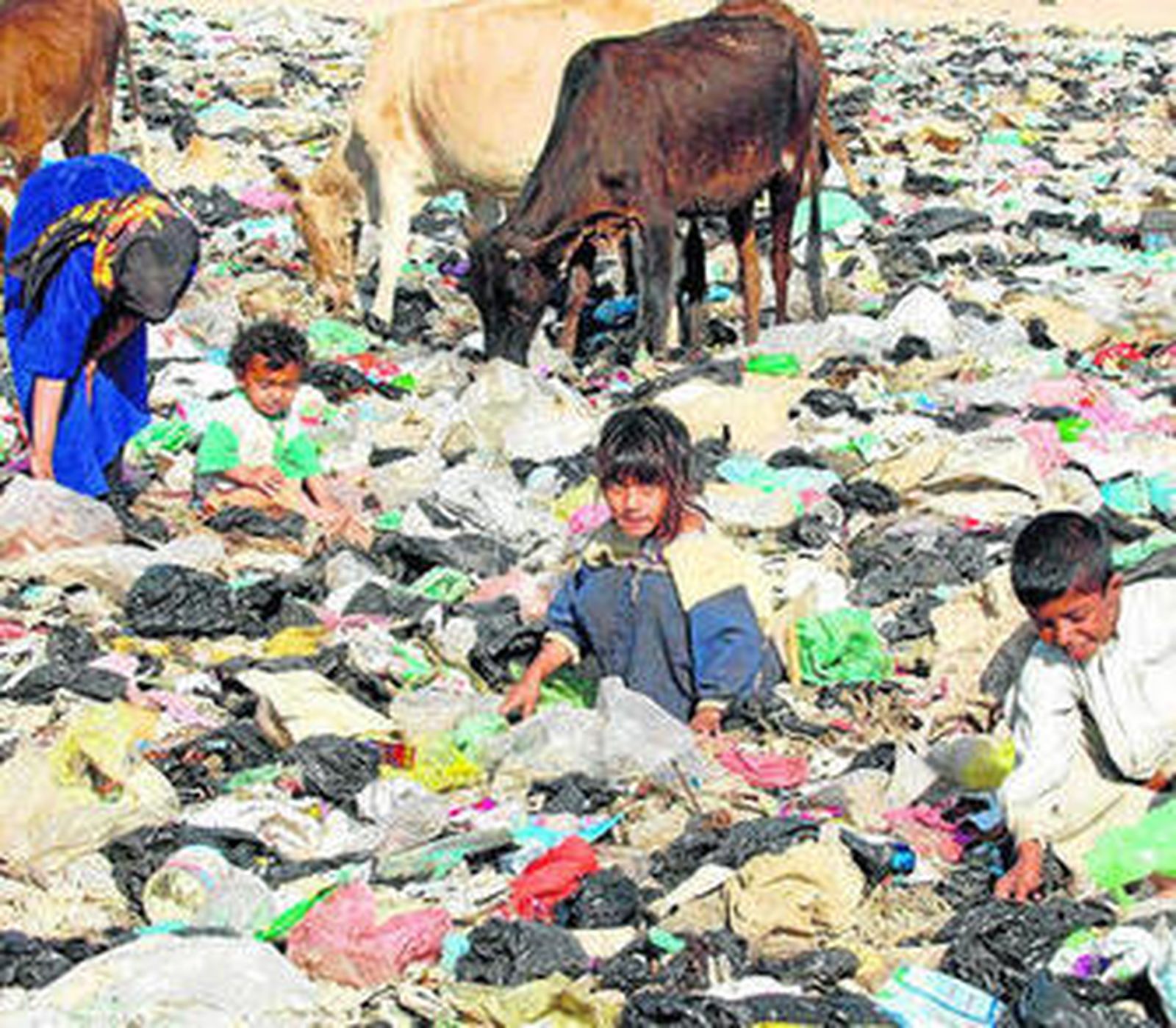 Unos niños iraquíes buscan entre la basura de un vertedero a las afueras de Bagdad.