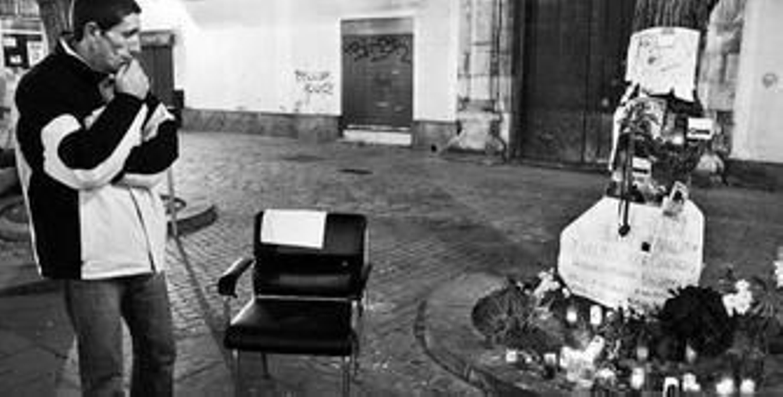 Un vecino del Pumarejo observa las flores y carteles depositados en el lugar del crimen.