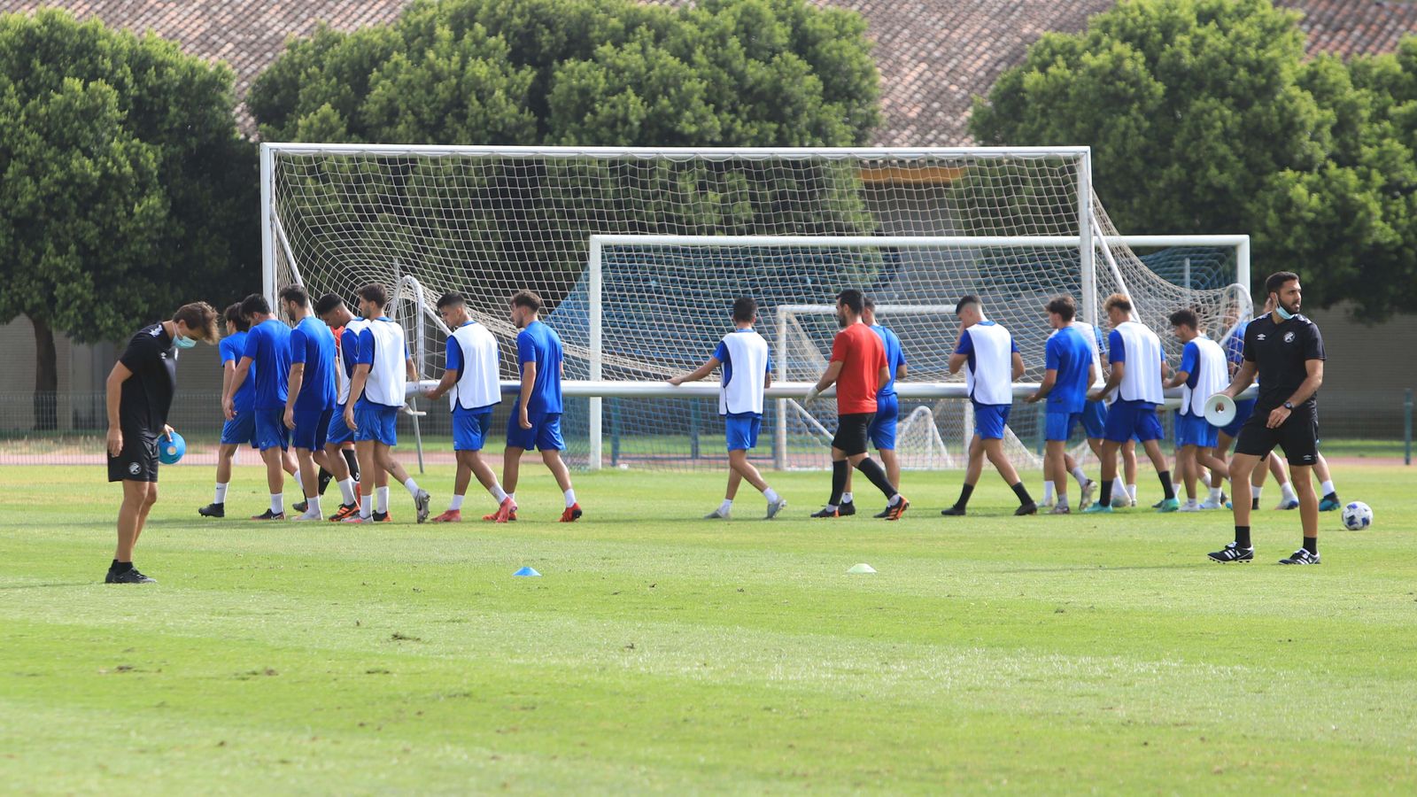 Los jugadores del Xerez DFC, con ganas de medirse al Castilla, transportan una portería en el Pepe Ravelo.