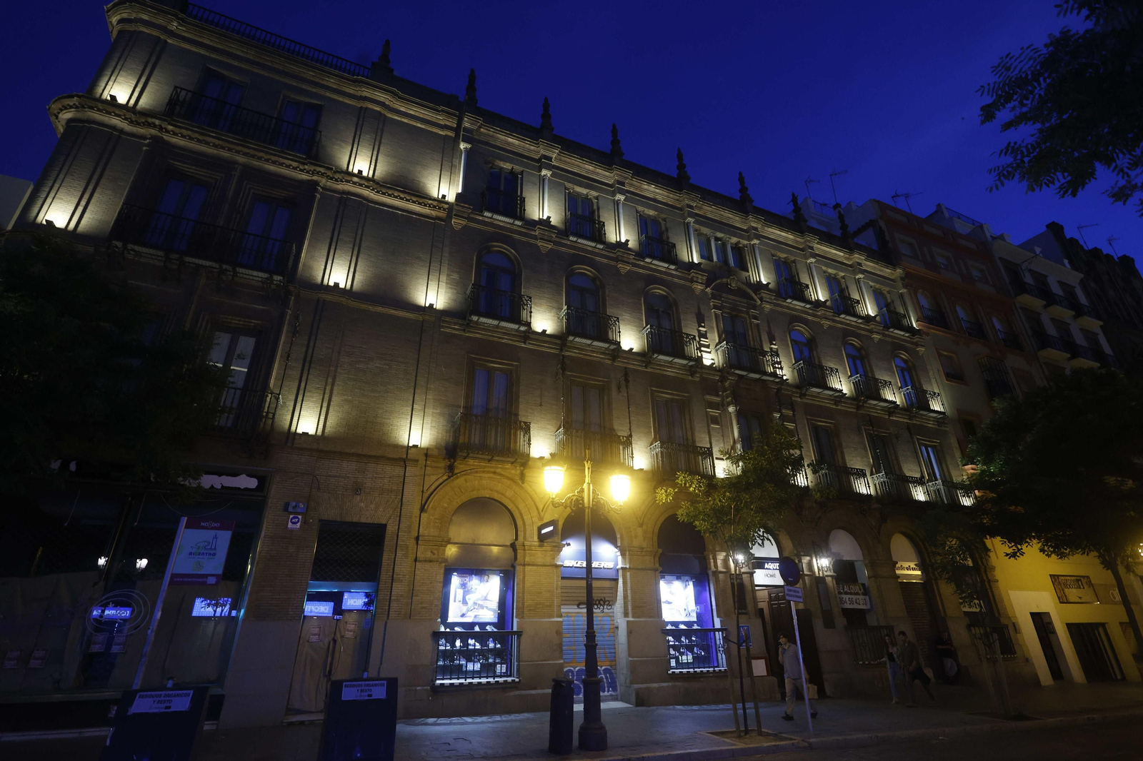 Un inmueble de apartamentos turísticos con la fachada iluminada en la calle Martín Villa.
