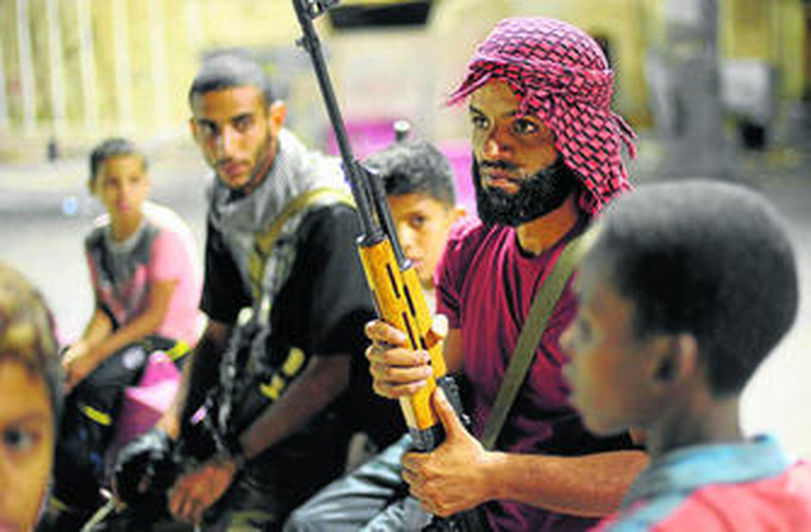 Un rebelde patrulla por la carretera que conduce al aeropuerto de Trípoli, en manos de los insurgentes.