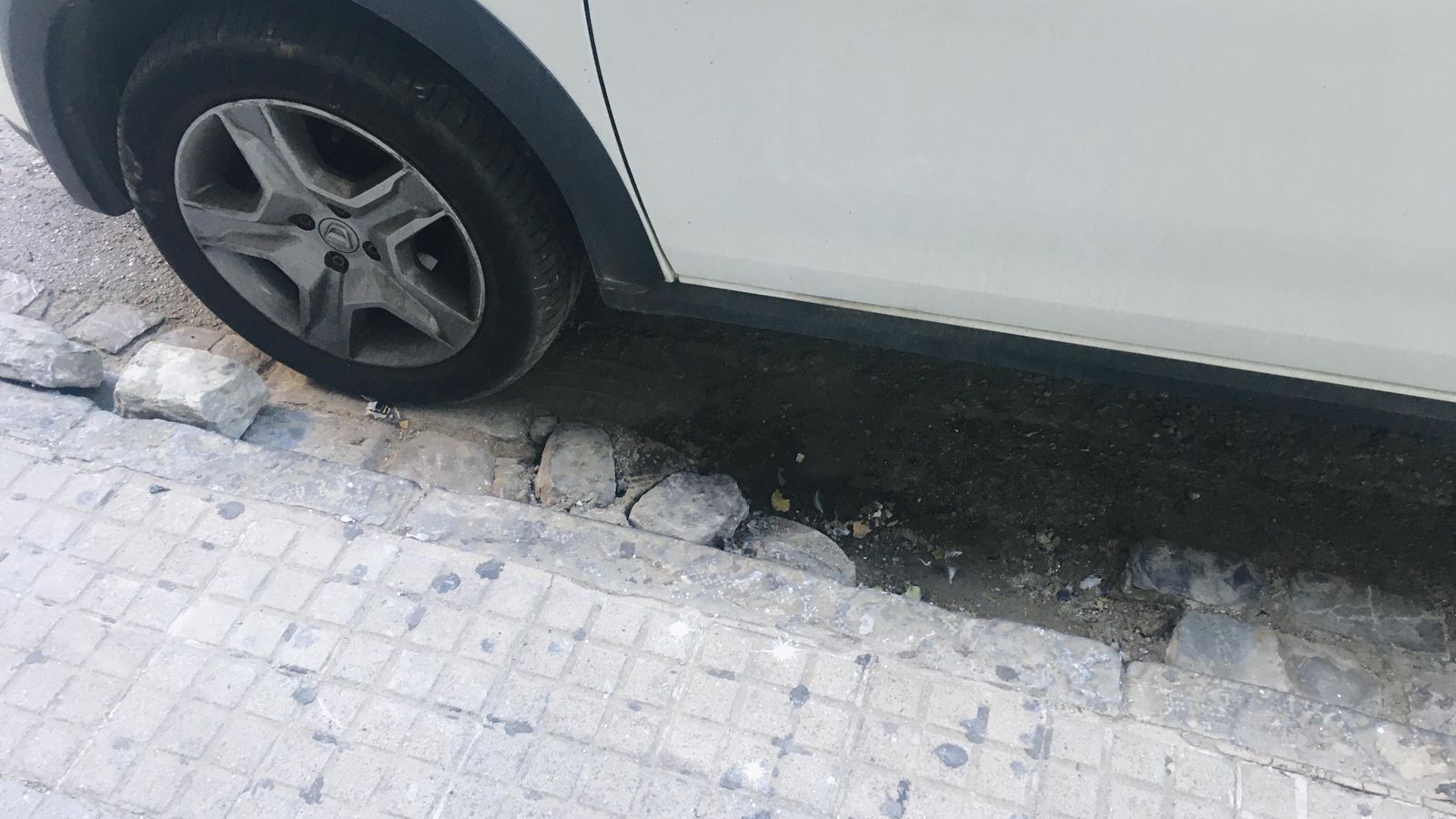 Baches y adoquines sueltos en la calle Agentes Comerciales de Algeciras.