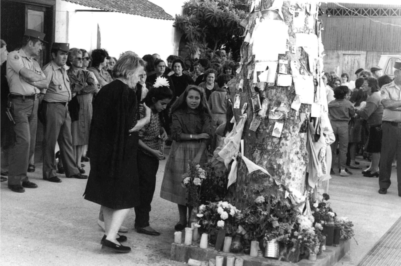 Niñas y mujeres alrededor del árbol de la Virgen, a la espera del milagro anunciado.