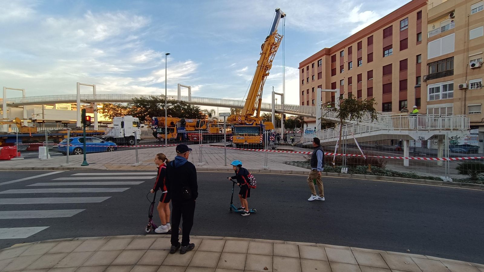 Niños en patinete circulan ante la calle cortada por obras