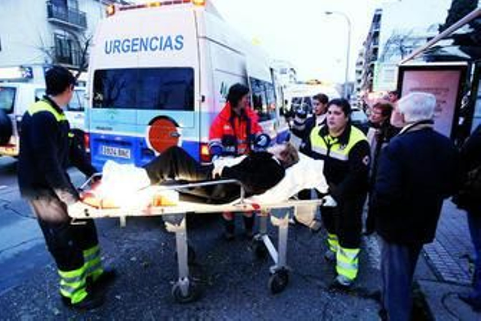 Efectivos del 061 llevan en camilla a una de las tres mujeres implicadas en el accidente registrado junto a la parada de autobús de Las Ollerías.