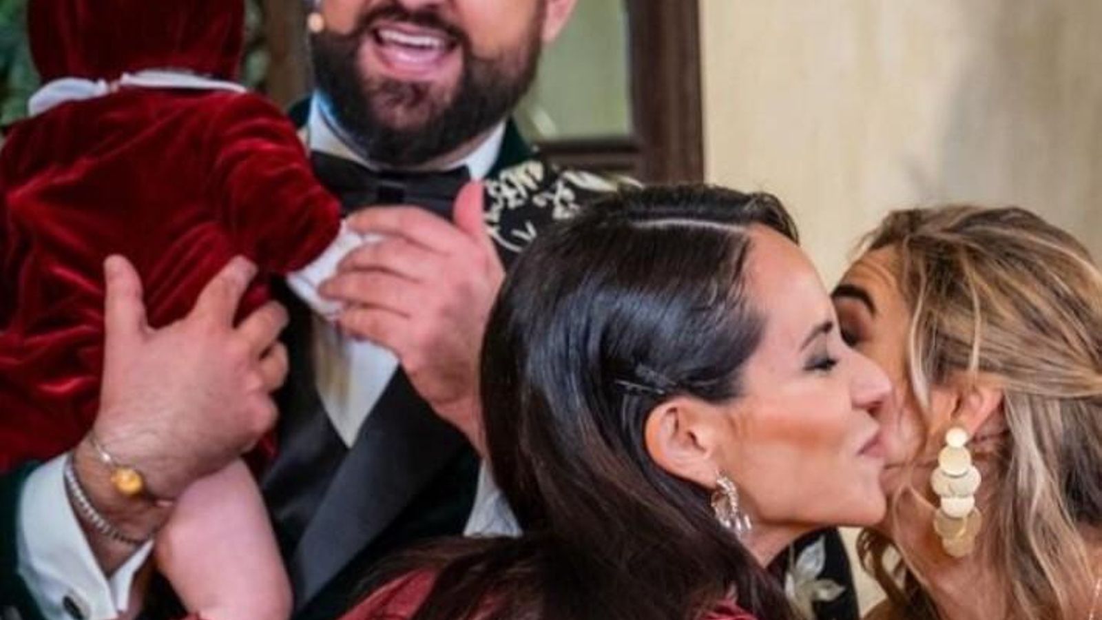 Manu Sánchez, con su hija Leonor en brazos, y Lorena Sánchez, besando a Olga Carmona, tras la retransmisión de las campanadas