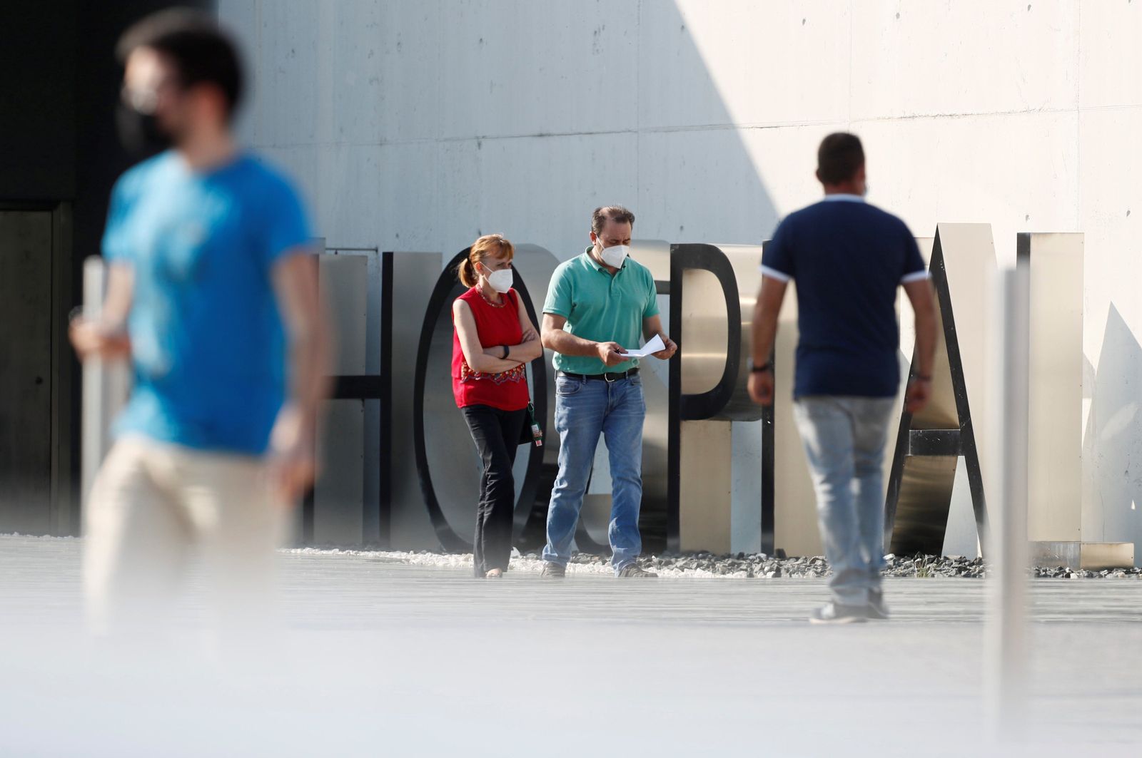 Varias personas camina junto al hospital de Lugo.