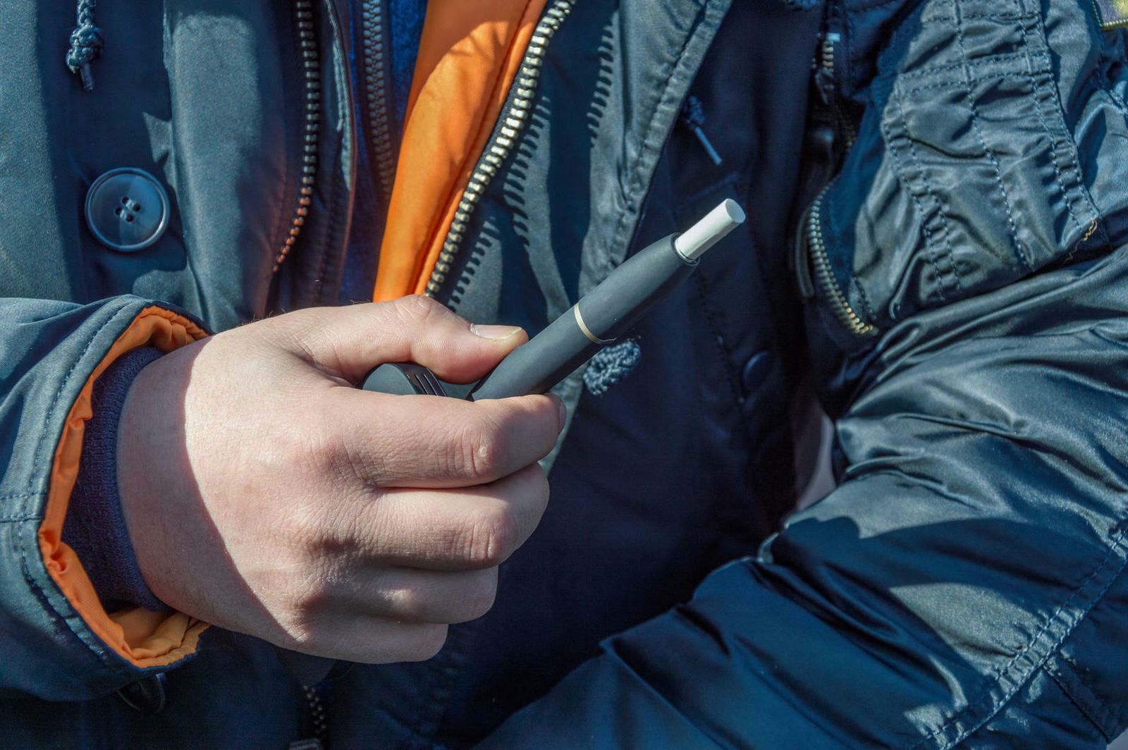 Un fumador sostiene el disponitivo Iqos con un cigarrillo.